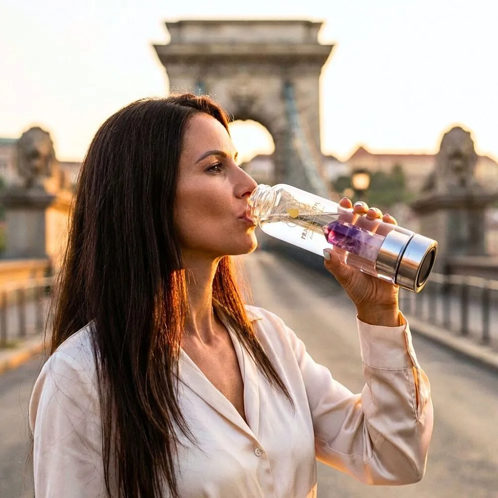 Hölgy ametiszt kristálykulacsból iszik Budapesten, prémium üveg kulaccsal és valódi ametiszt ásványbetéttel